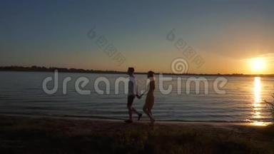 一对情侣在日落热带背景下的剪影。